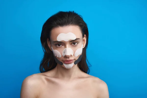 Perempuan muda dengan tambalan kosmetik di wajah — Stok Foto