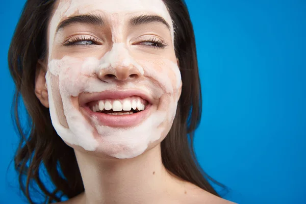 Jovem mulher feliz com máscara cosmética no rosto — Fotografia de Stock