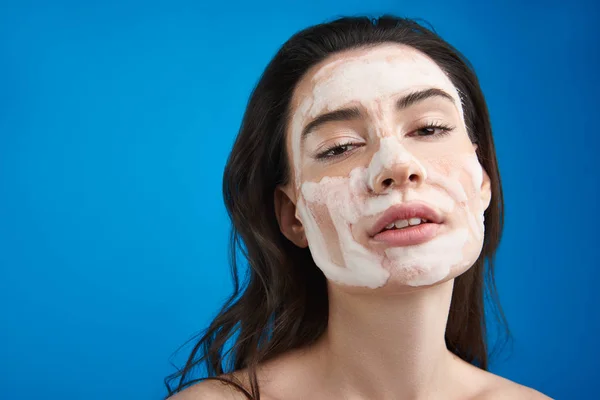 Nahaufnahme junge Frau mit kosmetischer Maske im Gesicht — Stockfoto