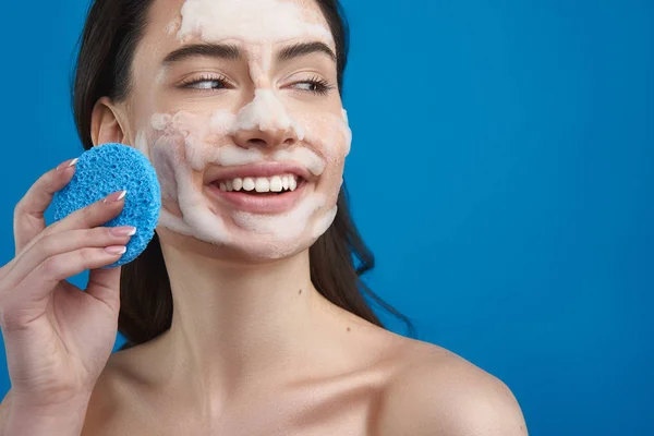 Mujer bonita sonriente con máscara cosmética en la cara —  Fotos de Stock