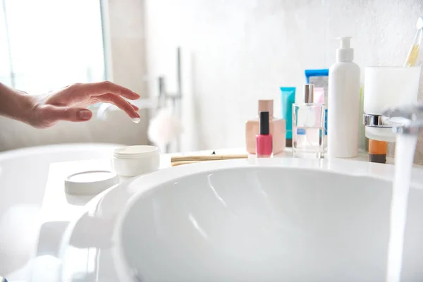 Jovencita tomando gota de crema facial en el dedo — Foto de Stock