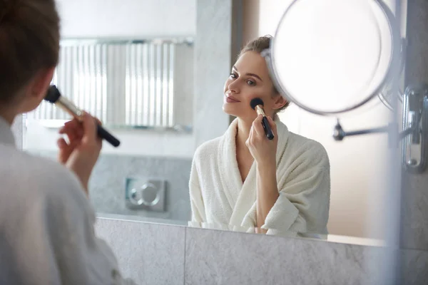 Young lady laying powder blusher on cheek — Stock Photo, Image