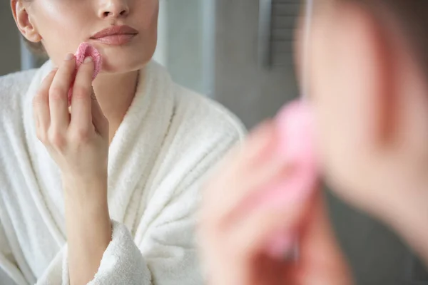 Крупный план юной леди с помощью губки в макияже — стоковое фото