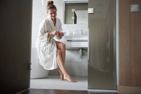 Joven dama sonriente haciendo pedicura en el baño —  Fotos de Stock