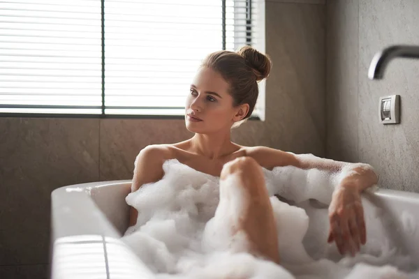 Jovem senhora cuidadosa tomando banho de espuma relaxado — Fotografia de Stock