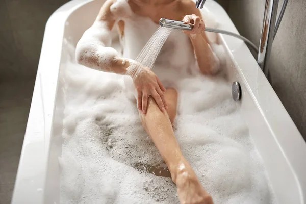 Jeune femme se douchant en prenant un bain de mousse — Photo