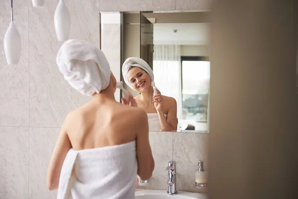Mladá dáma zábal v ručníku čištění obličeje — Stock fotografie