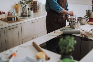 Mutfak masası ve cam kavanoza el koyan kişi