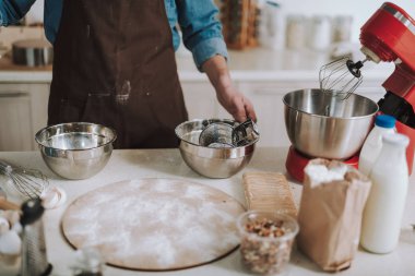 Pişirme ekipmanları ve ayakta kişi ile mutfak masası