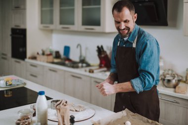 Mutlu adam pişirme kağıdı üzerinde pasta bakıyor