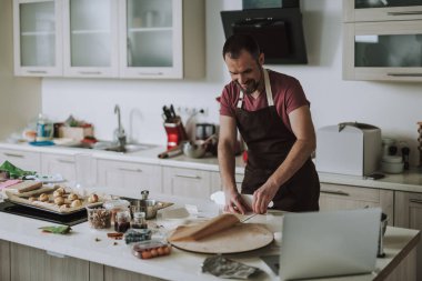 Neşeli sakallı adam gülümseyen ve masada karton sahip