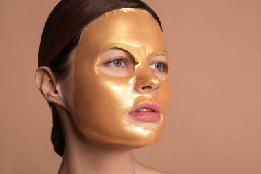 Parlak çarşaf maskesi takan ve başka tarafa bakan kadın.