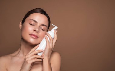 Barışçıl kadın yavaşça dispenser ile plastik şişe sarılma