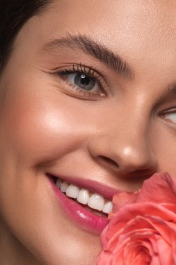 Yanında pembe gül tomurcuklu genç kadının yüzü