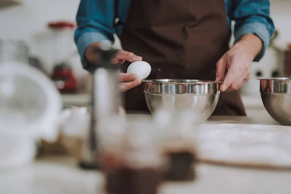 Selective focus of the person cracking one egg