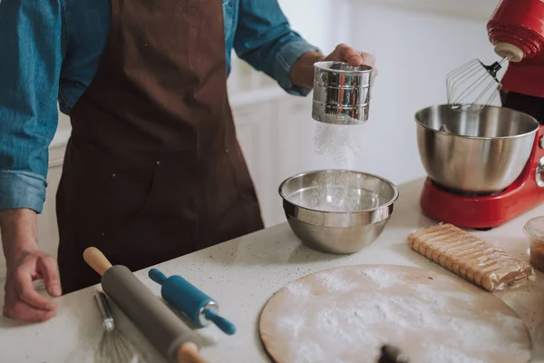 Άνθρωπος που κρατά το φλιτζάνι σχήμα αλεύρι σιφτέρ ενώ το μαγείρεμα — Φωτογραφία Αρχείου