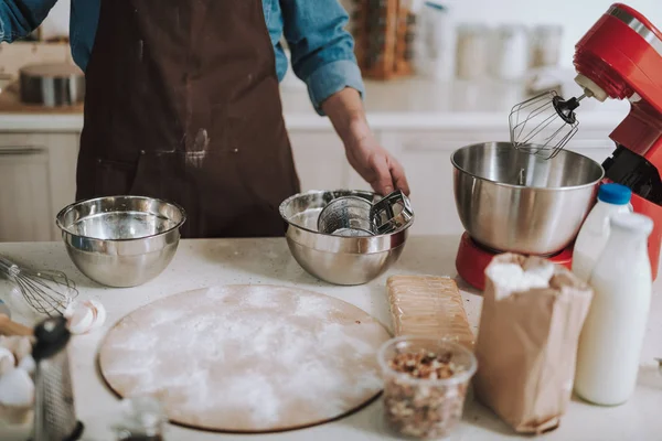 Pişirme ekipmanları ve ayakta kişi ile mutfak masası