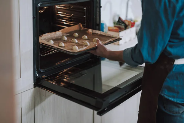 Cerrar el horno abierto y poner a mano la bandeja de la hoja en él — Foto de Stock