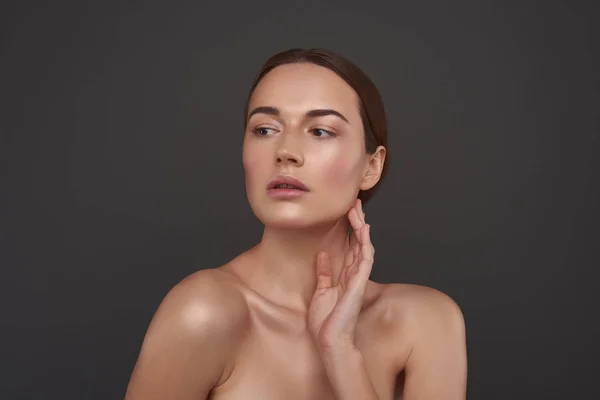 Schönes Mädchen mit natürlichem Make-up, das ihre seidige Haut berührt — Stockfoto