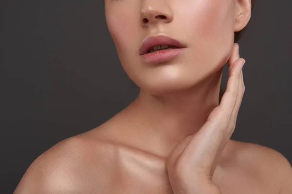 Vacker ung kvinna med perfekt slät hud vidrör hennes ansikte — Stockfoto