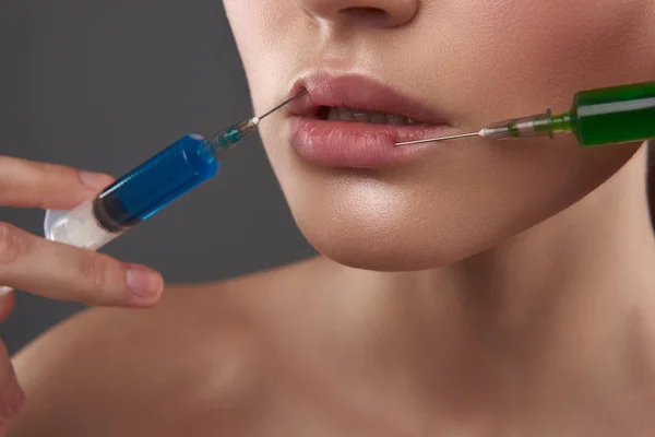 Fiatal nő, aki injekciót ad az ajkába. — Stock Fotó