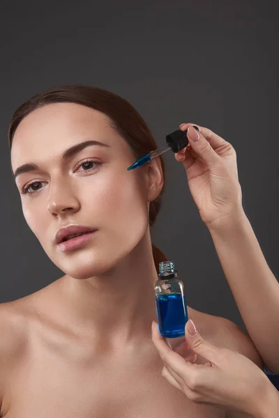 Kosmetolog tillämpa vitamin serum på Lady Face — Stockfoto