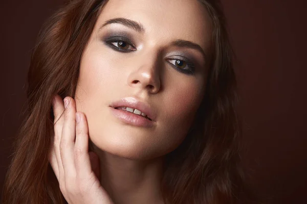 Atractiva joven mujer con ojos ahumados maquillaje tocando su cara —  Fotos de Stock