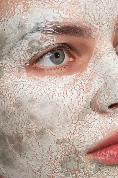 Szara Eyed kobieta patrząc z dala podczas gdy glina maska na jej skórze — Zdjęcie stockowe
