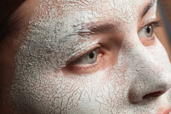 Bagian dari wajah wanita dengan masker tanah liat retak di atasnya — Stok Foto