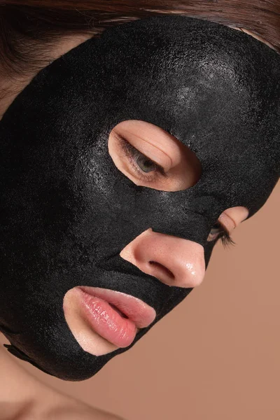 Portré komoly nő, fekete lap maszk az arcon — Stock Fotó