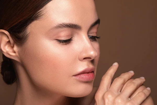 Calm woman touching her shoulder and looking at the fingers — Stock Photo, Image