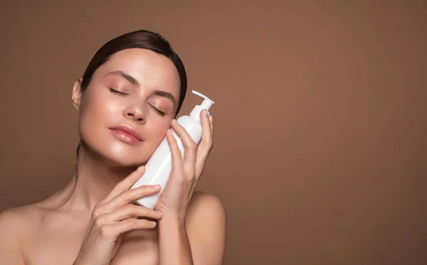 Mujer pacífica abrazando suavemente la botella de plástico con dispensador — Foto de Stock