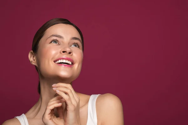 Mulher encantada sorrindo e olhando para cima enquanto está sozinha — Fotografia de Stock