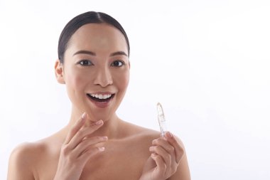 Heyecanlı Asyalı bayan şeffaf ruj sahip ve mutlu görünümlü