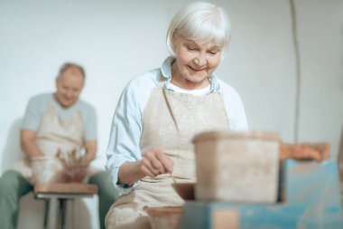 Kadın kil ustası atölyesinde toprak üzerinde süs yapma