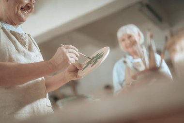 Çömlekçi stüdyosunda çalışan yaşlı erkek sanatçının bel kadar