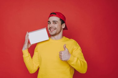 Genç adam içinde Cap tutan bir kutu ve gösteren Thumb yukarı