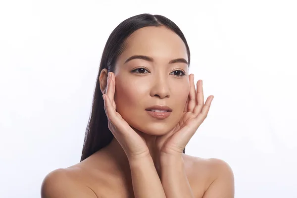 Calm Asian woman touching her face with two hands — Stock Photo, Image