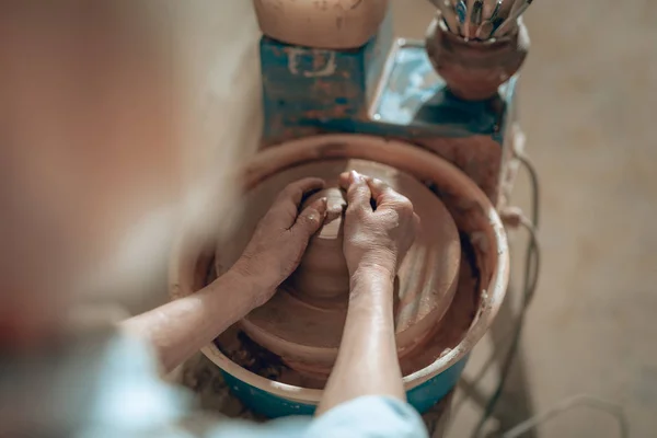 Foto recortada de manos femeninas con arcilla en taller — Foto de Stock