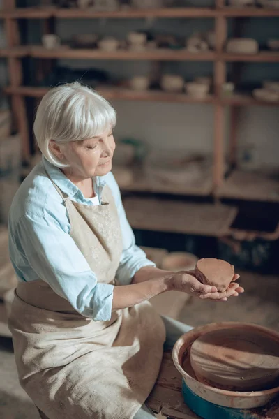 Alto ángulo de la artesana madura haciendo productos de arcilla en el estudio de alfareros — Foto de Stock