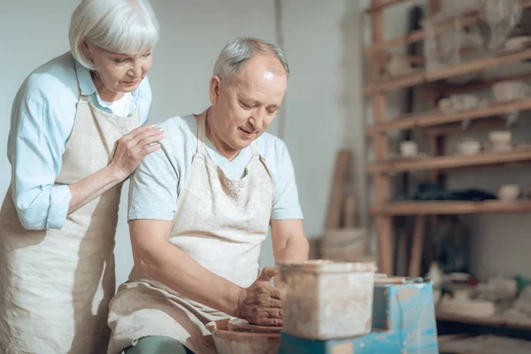 Pareja mayor disfrutando del trabajo con arcilla húmeda en taller de cerámica — Foto de Stock