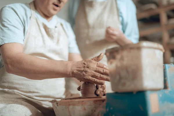 Χαμηλή γωνία των αρσενικών χεριών που εργάζονται με βρεγμένο πηλό σε Πότερ στούντιο — Φωτογραφία Αρχείου