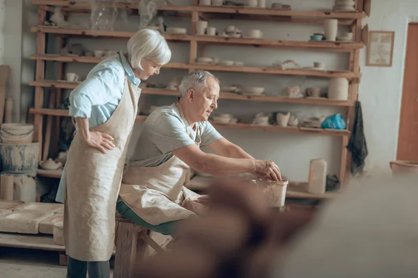 Foto recortada de pareja mayor en delantales trabajando en el estudio de alfareros — Foto de Stock