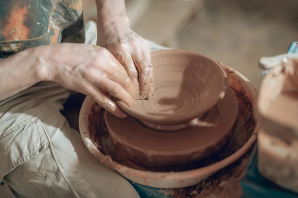 Высокий угол глины мастера грязные руки, работающие на гончарных колесах — стоковое фото