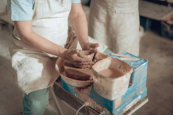 Высокий угол ремесленника, формирующего глиняную посуду в мастерской гончаров — стоковое фото