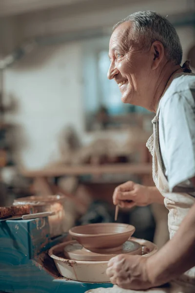 Zijaanzicht van Kaukasische ambachtsman werken in Potters Studio — Stockfoto