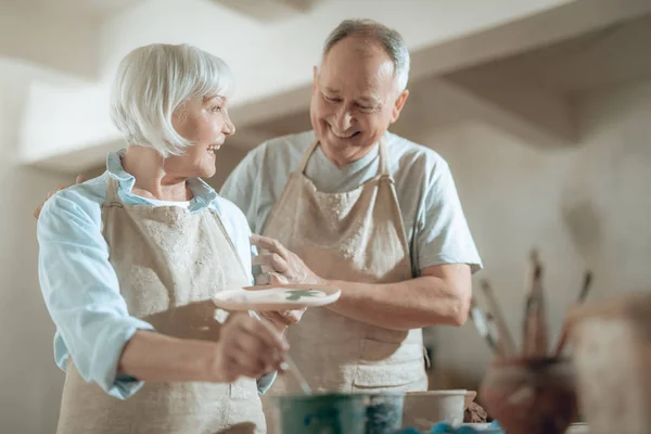 Bajo ángulo de felices artistas ancianos riendo en el estudio de alfareros — Foto de Stock