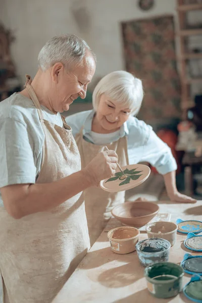 Media duración de la pareja de ancianos que trabajan en el estudio de alfareros —  Fotos de Stock