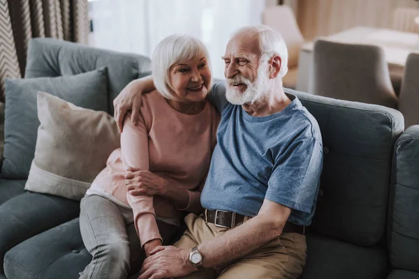 Feliz pareja de ancianos abrazándose en el sofá en casa — Foto de Stock