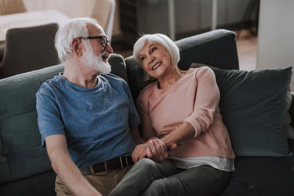 Happy elder couple sitting together on sofa